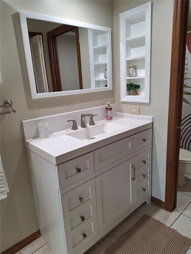 bathroom with built in shelves, tile patterned flooring, vanity, and toilet