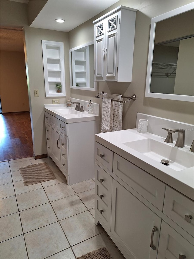 bathroom with built in shelves, vanity, and tile patterned floors