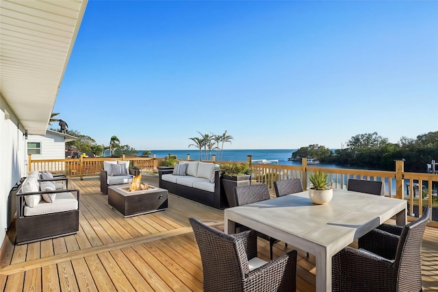 wooden deck featuring a water view and an outdoor living space with a fire pit