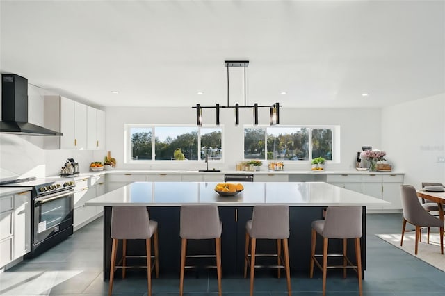 kitchen with black appliances, wall chimney exhaust hood, and a kitchen island