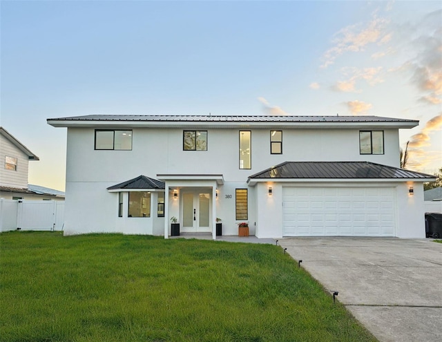 view of front of home featuring a garage and a lawn