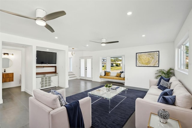 living room featuring french doors, ceiling fan, and concrete floors