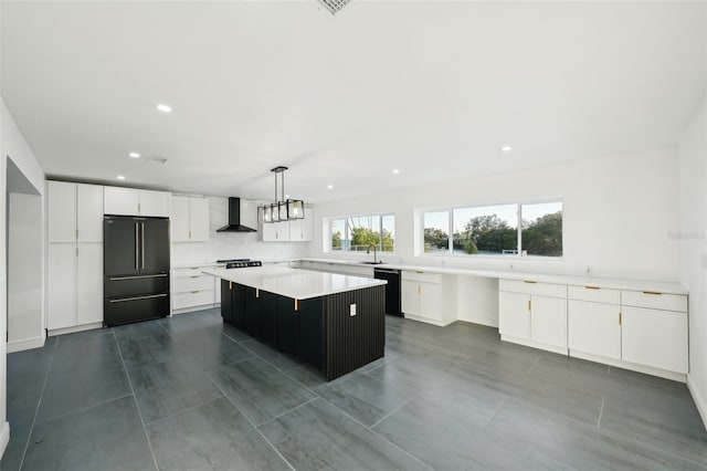 kitchen with wall chimney exhaust hood, black appliances, a kitchen island, pendant lighting, and white cabinets