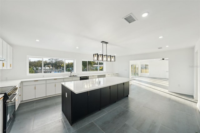 kitchen featuring sink, white cabinetry, pendant lighting, a large island, and black appliances