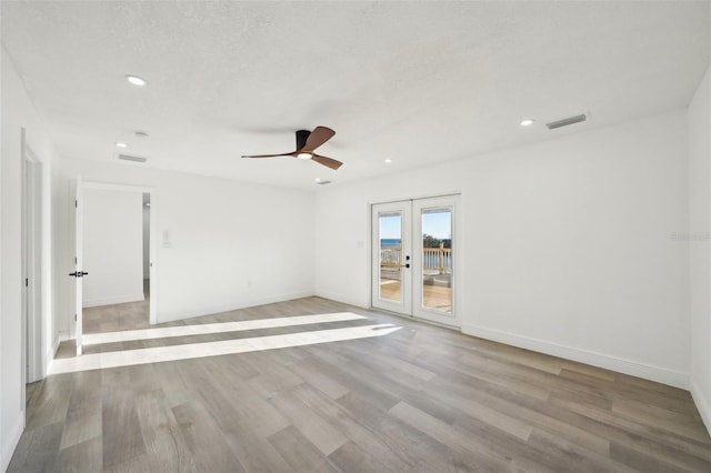 unfurnished room with french doors, ceiling fan, light hardwood / wood-style flooring, and a textured ceiling