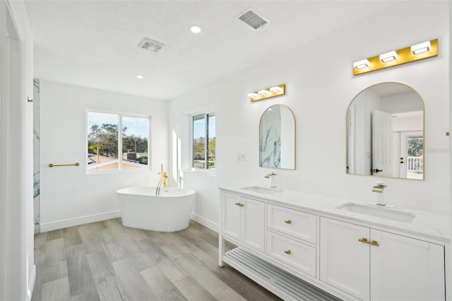 bathroom featuring vanity, a bathing tub, and hardwood / wood-style floors