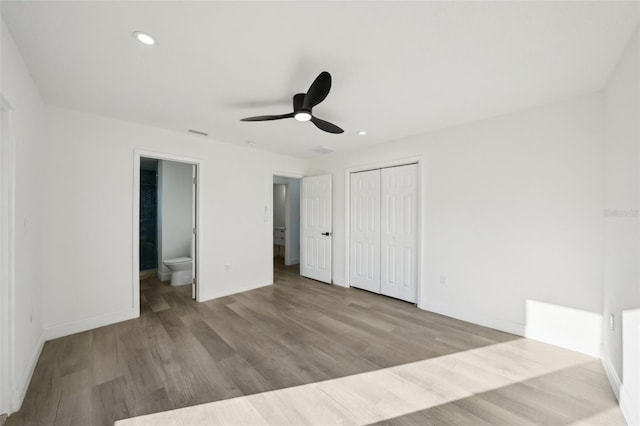 unfurnished bedroom featuring connected bathroom, light hardwood / wood-style flooring, a closet, and ceiling fan