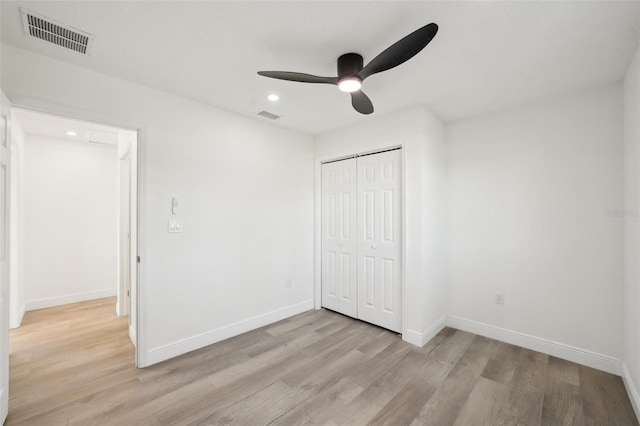 unfurnished bedroom featuring light wood-type flooring, ceiling fan, and a closet