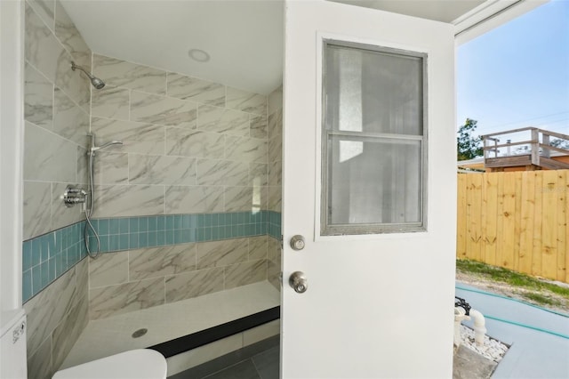 bathroom with toilet and a tile shower