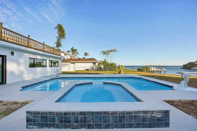 view of swimming pool with an in ground hot tub and a water view