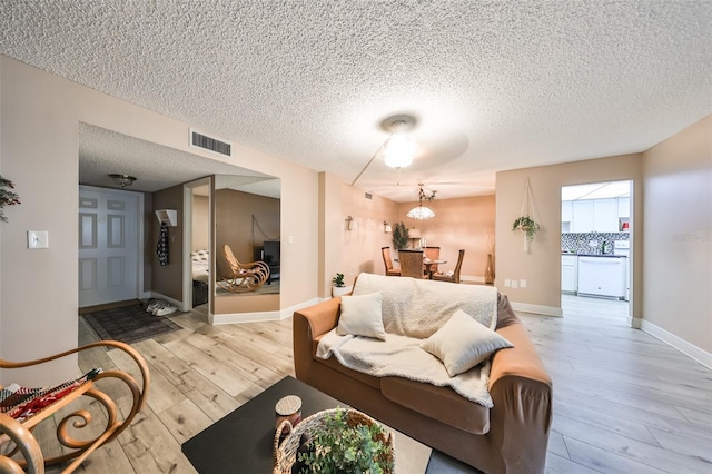 living room featuring light hardwood / wood-style floors and a textured ceiling