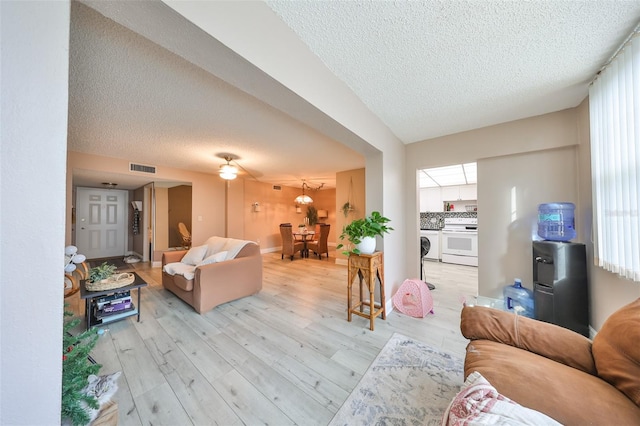 living room featuring a textured ceiling and light hardwood / wood-style flooring