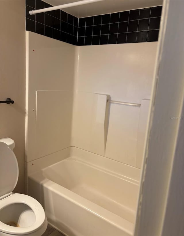 bathroom with washtub / shower combination and toilet