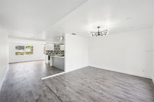 unfurnished living room featuring a chandelier and hardwood / wood-style flooring