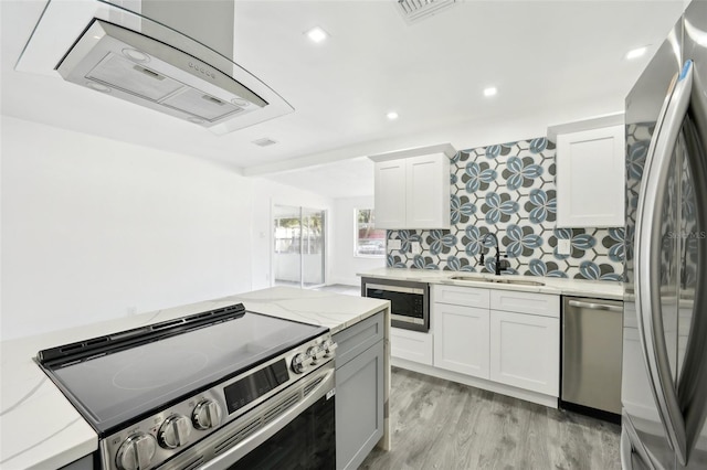 kitchen featuring backsplash, light stone counters, stainless steel appliances, sink, and white cabinets