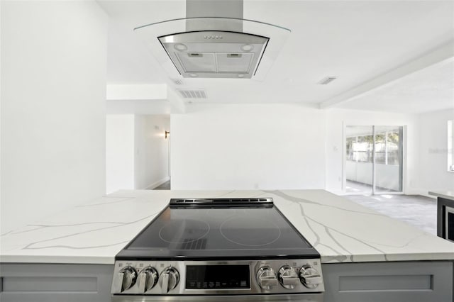 kitchen featuring gray cabinetry, stainless steel range oven, and light stone countertops