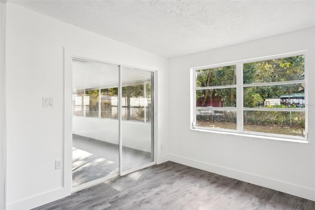 unfurnished bedroom featuring a closet, wood-type flooring, and a textured ceiling