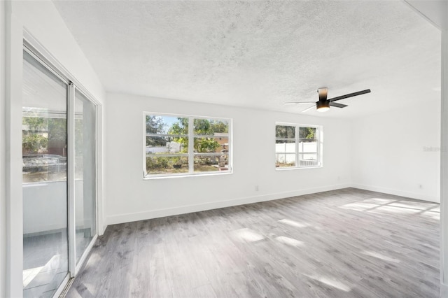 empty room with ceiling fan, hardwood / wood-style floors, and a textured ceiling