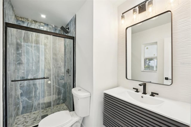 bathroom with vanity, toilet, and a shower with door