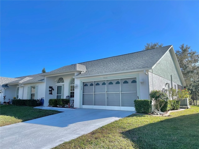 ranch-style home with a garage and a front lawn