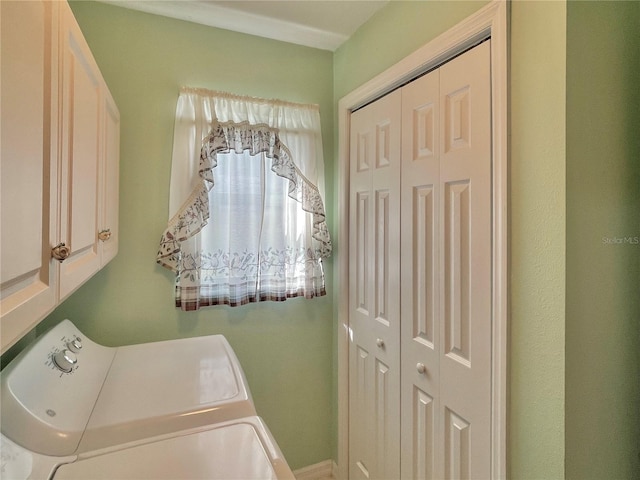 washroom with washing machine and dryer and cabinets