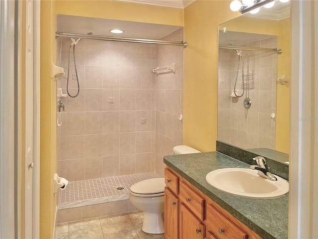 bathroom featuring crown molding, toilet, tiled shower, and vanity