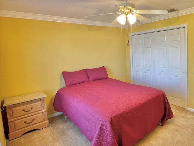 carpeted bedroom featuring a closet, ceiling fan, and ornamental molding