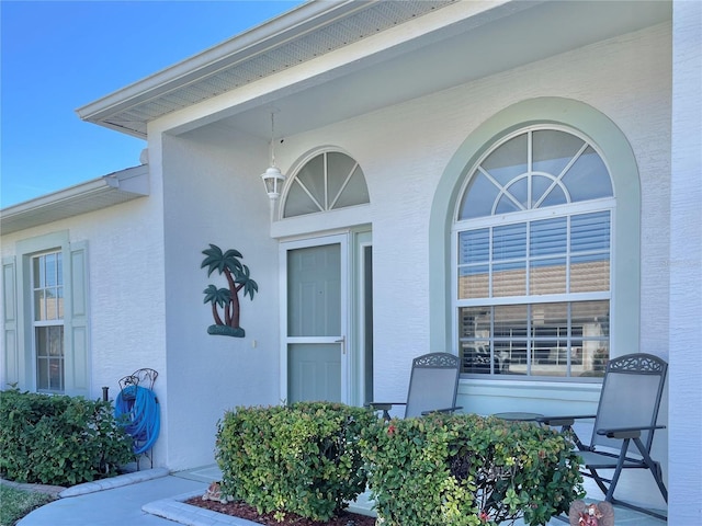 doorway to property featuring stucco siding