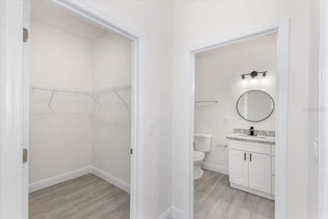 bathroom featuring hardwood / wood-style floors, vanity, and toilet