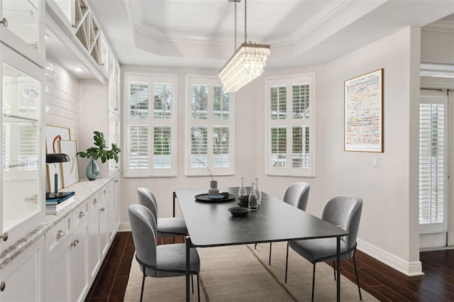 dining area with ornamental molding, a raised ceiling, a wealth of natural light, and a notable chandelier