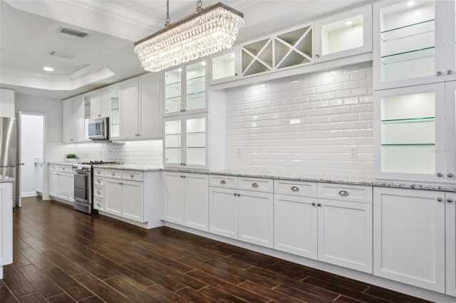 kitchen featuring white cabinets, decorative light fixtures, stainless steel appliances, and an inviting chandelier