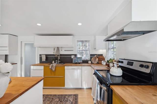 kitchen featuring black electric range, white dishwasher, white cabinets, and range hood