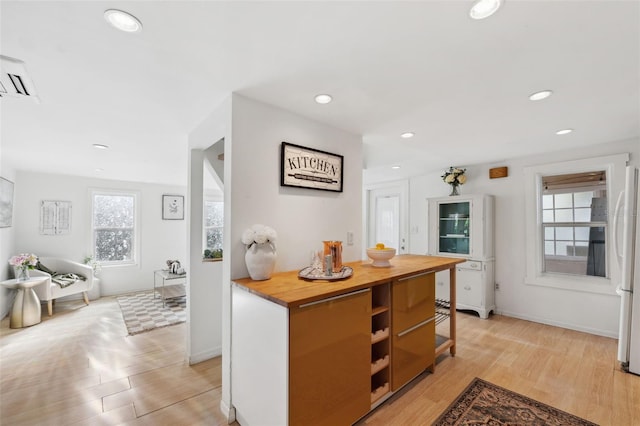 kitchen featuring white refrigerator, butcher block countertops, and light hardwood / wood-style flooring