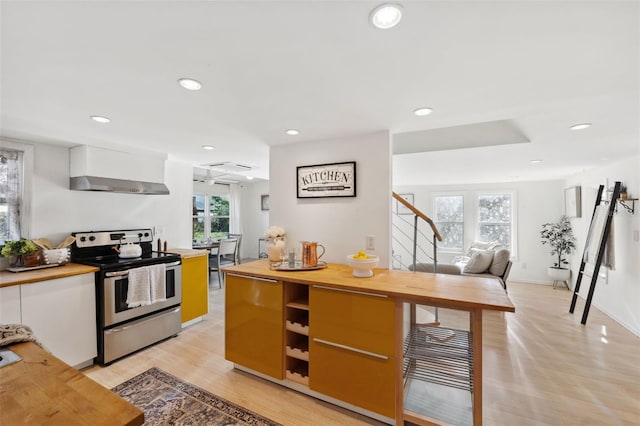 kitchen featuring white cabinets, light wood-type flooring, electric stove, and extractor fan