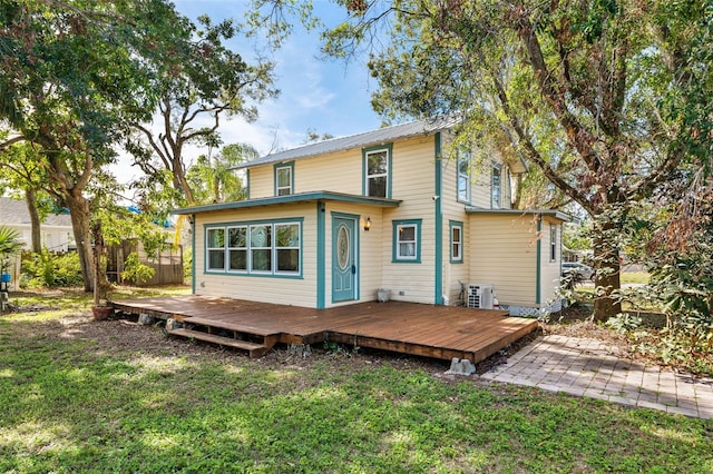 rear view of property with a deck and a lawn