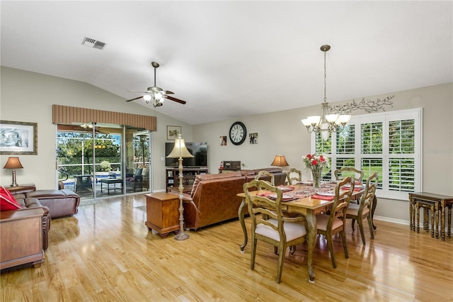 dining space with vaulted ceiling, plenty of natural light, light hardwood / wood-style floors, and ceiling fan with notable chandelier