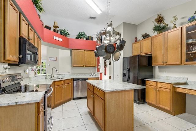 kitchen featuring black appliances, a kitchen island, light tile patterned flooring, and sink