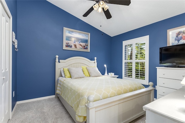 bedroom featuring a closet, ceiling fan, lofted ceiling, and light colored carpet