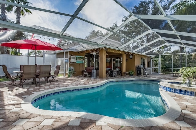 view of pool with an in ground hot tub, a patio, and glass enclosure