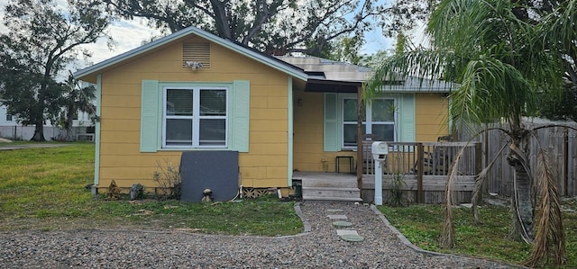 bungalow-style home featuring a front lawn and solar panels