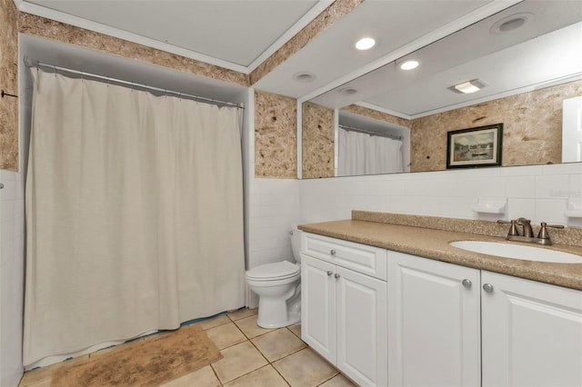 bathroom featuring tile patterned floors, ornamental molding, vanity, tile walls, and toilet