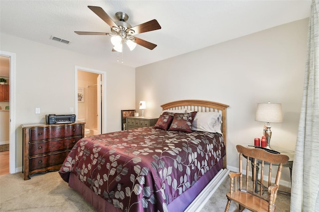 bedroom featuring connected bathroom, light colored carpet, and ceiling fan