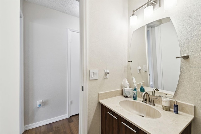 bathroom with vanity, wood-type flooring, and a textured ceiling