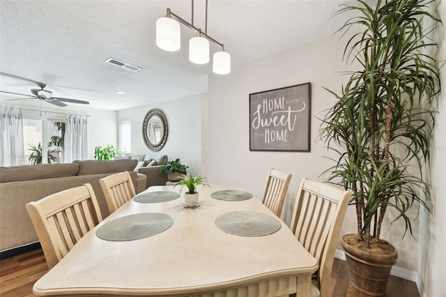 dining room featuring a textured ceiling, dark hardwood / wood-style floors, and ceiling fan