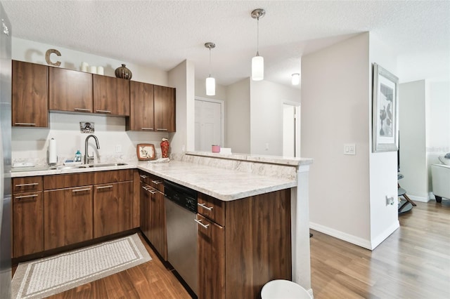 kitchen with kitchen peninsula, dishwasher, sink, and hardwood / wood-style floors