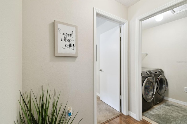 clothes washing area featuring washer and dryer and light wood-type flooring