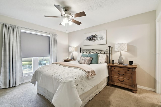 carpeted bedroom featuring ceiling fan and a textured ceiling