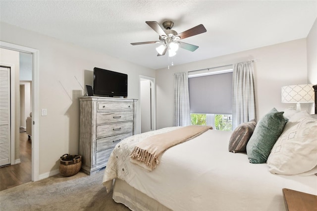 carpeted bedroom featuring a textured ceiling and ceiling fan