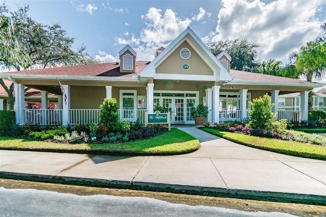 view of front facade with covered porch and french doors