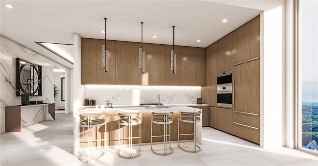 kitchen featuring sink, a kitchen bar, hanging light fixtures, and double oven